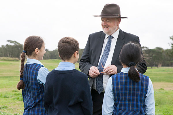 Principal Geoffrey Carey at St Michael's Catholic Primary School talking to student on a nature walk